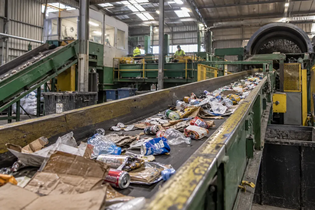 Mixed recyclables, cans, bottles and cardboard, on a sorting line conveyor in a materials recovery facility